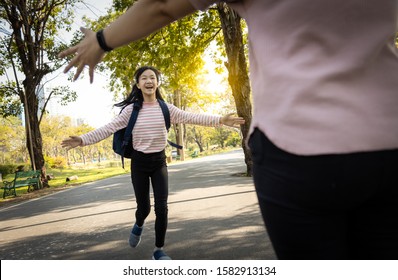 Happy Asian Child Daughter Running To Hug Her Mother With Love After Back School ,schoolgirl With Stretched Arms At Primary School,elementary Student Girl Run In To Mom’s Hands To Hug In Outdoor