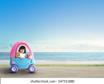 Happy Asian Child Driving Toy Car On Street Beside Beach