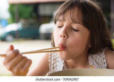 Happy Asian Child Eating Yellow Noodle, Thai Girl Eating Yellow Noodles 