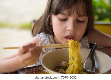 Happy Asian Child Eating Yellow Noodle, Thai Girl Eating Yellow Noodles 