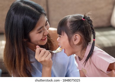 Happy Asian Child Enjoy Eating Tasty Cake With Her Older Sister, Love And Happiness Family Concept