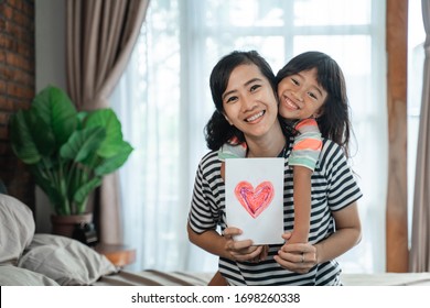 Happy Asian Child Giving Love Letter To Her Mother