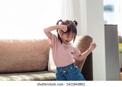 Happy Asian child having fun and dancing in a room, active leisure and lifestyle concept - Powered by Shutterstock