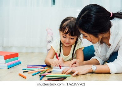 Happy Asian Child Kid Daughter Kindergarten And Young Beautiful Parent Mother Teaching Drawing And Play Color Together At Interior Room Home, Family Day And Back To School Concept