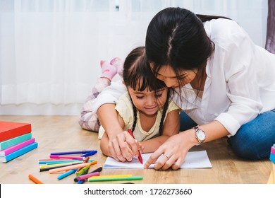Happy Asian child kid girl kindergarten drawing teacher education to paper and parent beautiful mom at interior room home  Mother day concept