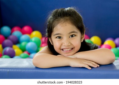 Happy Asian Child Playing At Kindergarten With Colorful Balls