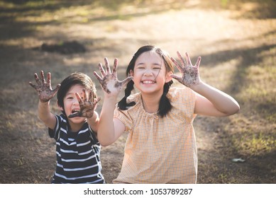 Happy Asian children playing outside with dirty hands - Shutterstock ID 1053789287