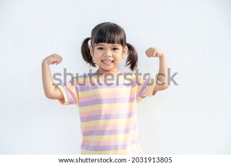Happy Asian children showing her strong hands
