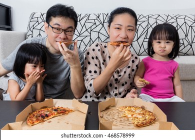 Happy Asian Chinese Family Eating Pizza Together At Home