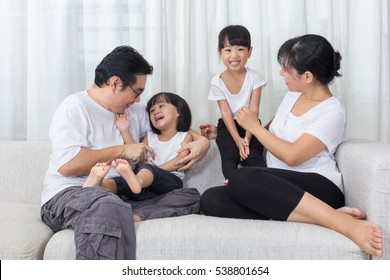 Happy Asian Chinese Family Sitting On The Couch In The Living Room At Home.