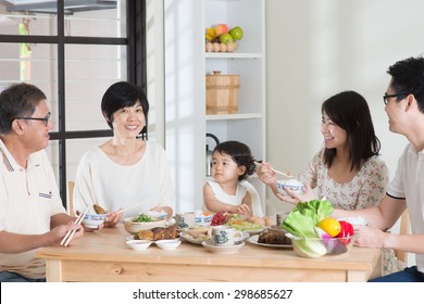 Happy Asian Chinese Multi Generations Family Dining At Home. Eating With Chopsticks.