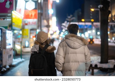 Happy Asian couple couple dating and shopping at retail store street market together in the city at night. Man and woman enjoy and fun outdoor lifestyle nightlife walking city street in winter night. - Powered by Shutterstock