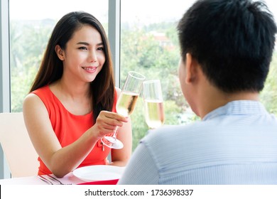 Happy Asian Couple Having Dinner Dating At Home. Hand Toasting Champagne Glass Celebrating On Anniversary, New Year, Birthday Or Valentine. Back To Normal Lifestyle. Love And Romantic Concept