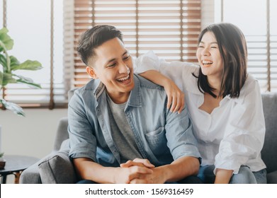 Happy asiatisches Ehepaar, das zu Hause im liebevollen Zimmer Spaß und Lachen hat