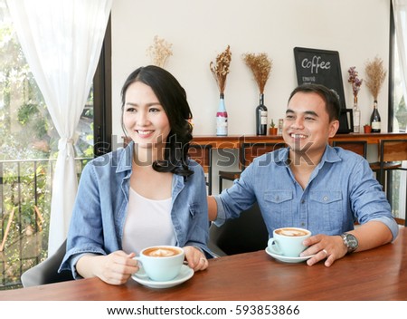 Happy Asian couple in jean shirt have hot heart shape latte art coffee together