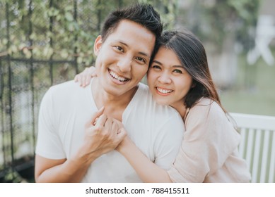 Happy Asian Couple In Love Smiling And Having Fun While Hugging Outdoor.