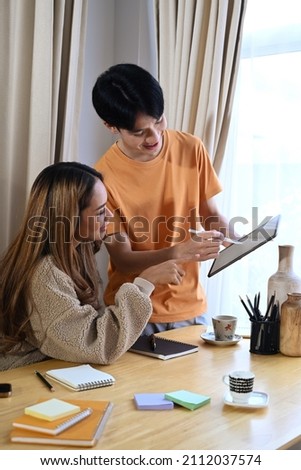 Happy Asian couple lover using digital tablet together for shopping online in living room.
