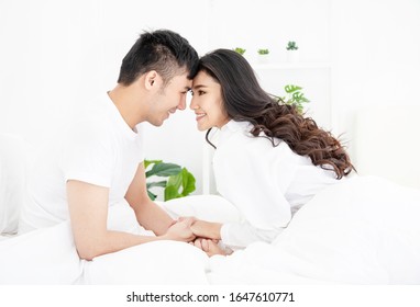 Happy Asian Couple On The Bed At Home, Lifestyle Concept.


