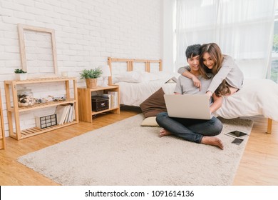 Happy Asian Couple planning and booking the hotel for travel with technology laptop on the bed of bedroom at the modern home, Life style and traveler concept, - Powered by Shutterstock