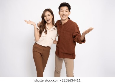 Happy Asian couple presenting or showing open hand palm with copy space for product isolated over white background - Shutterstock ID 2258634411