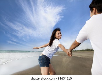 Happy Asian Couple Running On The Beach