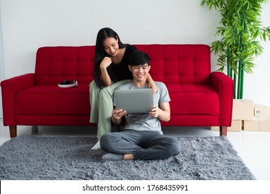 Happy Asian couple spending time together on sofa at home. - Shutterstock ID 1768435991