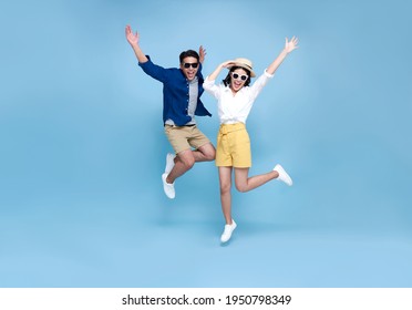 Happy Asian couple tourist jumping celebrating to travel on summer holiday isolated on blue background. - Powered by Shutterstock