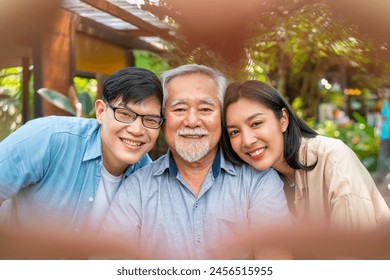 Happy Asian couple using mobile phone taking selfie with elderly father during having lunch eating food together at restaurant on summer vacation. Family relationship senior people health care concept - Powered by Shutterstock
