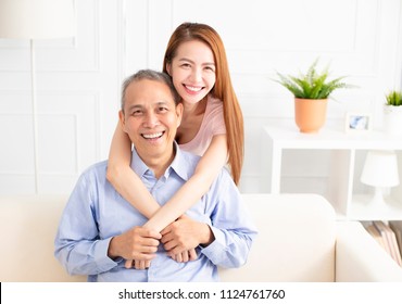 Happy Asian Daughter Holding Father On Sofa