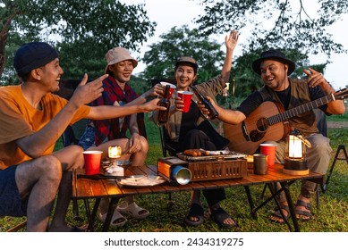 Happy asian diverse group friends enjoy drinking a beer together. They feeling relaxed and refreshing while camping in the nature at night. Recreation and journey outdoor activity lifestyle. - Powered by Shutterstock