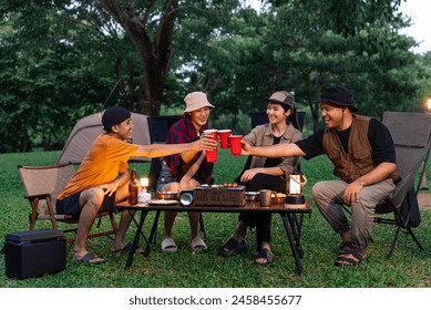 Happy asian diverse group friends enjoy drinking a beer together. They feeling relaxed and refreshing while camping in the nature at night. Recreation and journey outdoor activity lifestyle. - Powered by Shutterstock