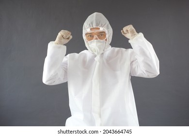 Happy Asian doctor wearing PPE protective with winning celebration gesture - Shutterstock ID 2043664745