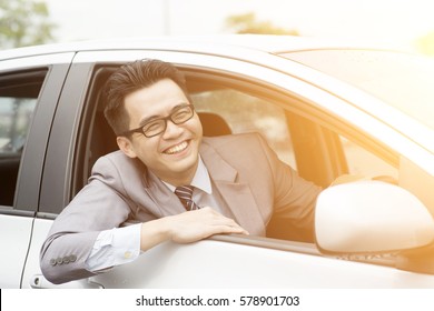 Happy Asian Driver Sitting In His Car And Smiling.