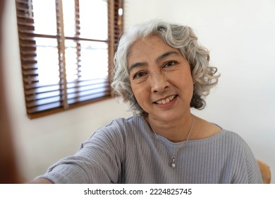 Happy Asian Elderly taking selfie photos with smartphone together in house. Portrait Senior people smiling and looking at camera. - Powered by Shutterstock