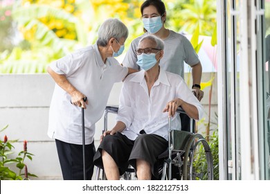 Happy Asian Elderly Woman Wearing Medical Mask Sit In Wheelchair With Female Caregiver,best Friend Or Her Family Visit To The Home During COVID-19,Coronavirus Pandemic,senior People Embracing Enjoy