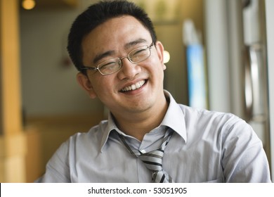 happy asian employee laughing at workplace.