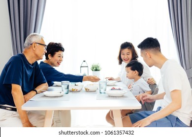 Happy Asian Extended Family Having Dinner At Home Full Of Laughter And Happiness