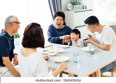 Happy Asian Extended Family Having Dinner At Home Full Of Laughter And Happiness