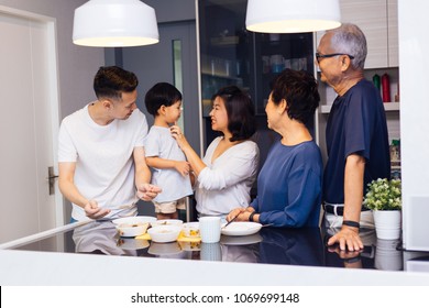 Happy Asian Extended Family Preparing Food At Home Full Of Laughter And Happiness