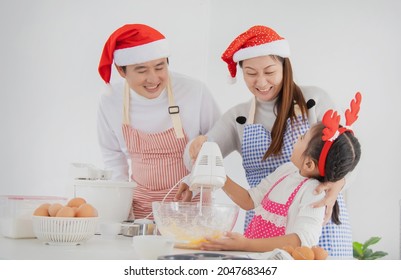 Happy Asian Family Baking Cooking Cake Together In Kitchen On Christmas Day