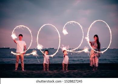 Happy Asian Family Celebrating New Year 2020 On The Beach