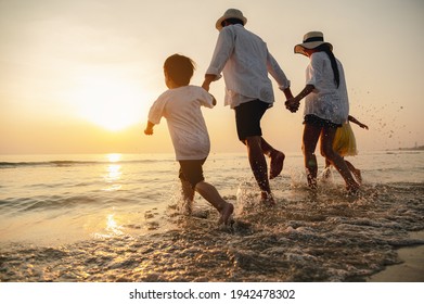 Happy asian family at consisting father, mother,son and daughter having fun playing beach in summer vacation on the beach.Happy family and vacations concept.   - Shutterstock ID 1942478302