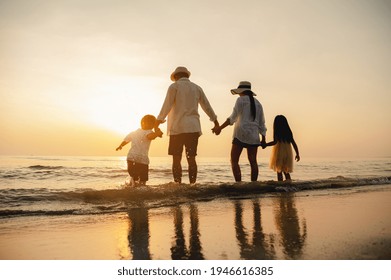 Happy Asian Family At Consisting Father, Mother,son And Daughter Having Fun Playing Beach In Summer Vacation On The Beach.Happy Family And Vacations Concept.  