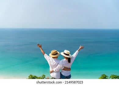 Happy Asian Family Couple Holding Hands And Walking Together While Travel On Tropical Island Mountain In Summer Sunny Day. Husband And Wife Enjoy Outdoor Lifestyle On Holiday Travel Beach Vacation