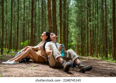 Happy Asian family couple travel on summer holiday vacation trip. Man and woman traveler enjoy outdoor active lifestyle hiking and resting together in pine tree forest mountain. - Shutterstock ID 2248745145