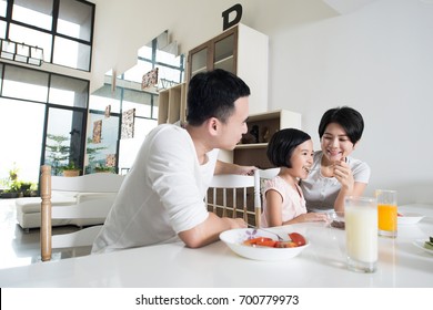 Happy Asian Family Enjoying A Healthy Snack At Home.