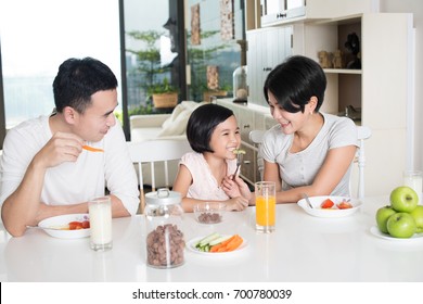 Happy Asian Family Enjoying A Healthy Breakfast At Home.