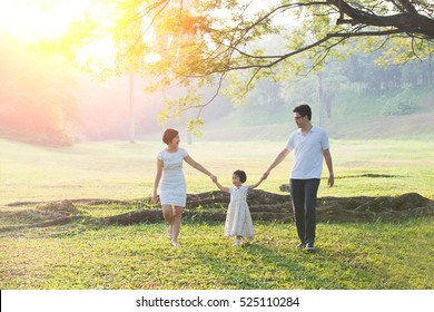 Happy Asian Family Enjoying Family Time Together In The Park

