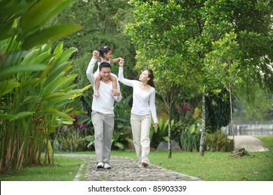 Happy Asian Family enjoying family time together in the park