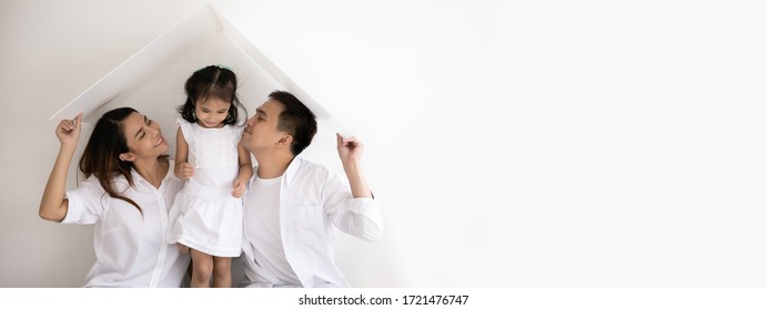 Happy Asian family. Father, mother and daughter in new house with white plastic roof. concept new housing of family with Copy space for website banner.